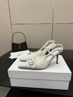White slingback pump heels with pointed toe, buckled strap, and high stiletto heel