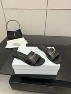 Pair of black leather slide sandals with wide textured strap and gold Dior lettering