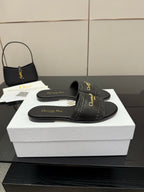 Black slip-on slide sandals with textured band strap and gold Dior logo on footbed