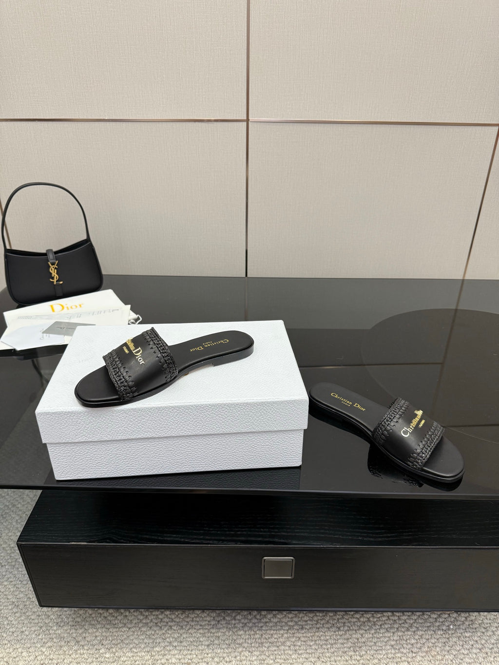 Black leather slide sandals shown with textured strap and gold Dior branding