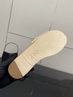 Women's slide sandal underside, cream outsole with logo stamp and star mark