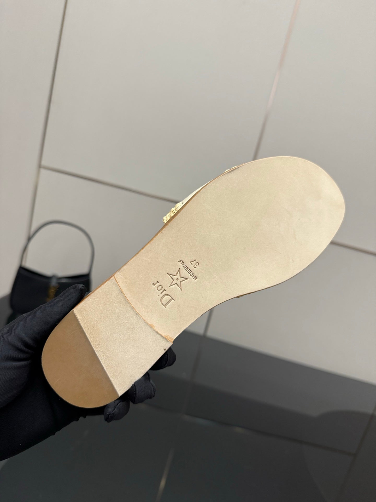 Women's slide sandal underside, cream outsole with logo stamp and star mark
