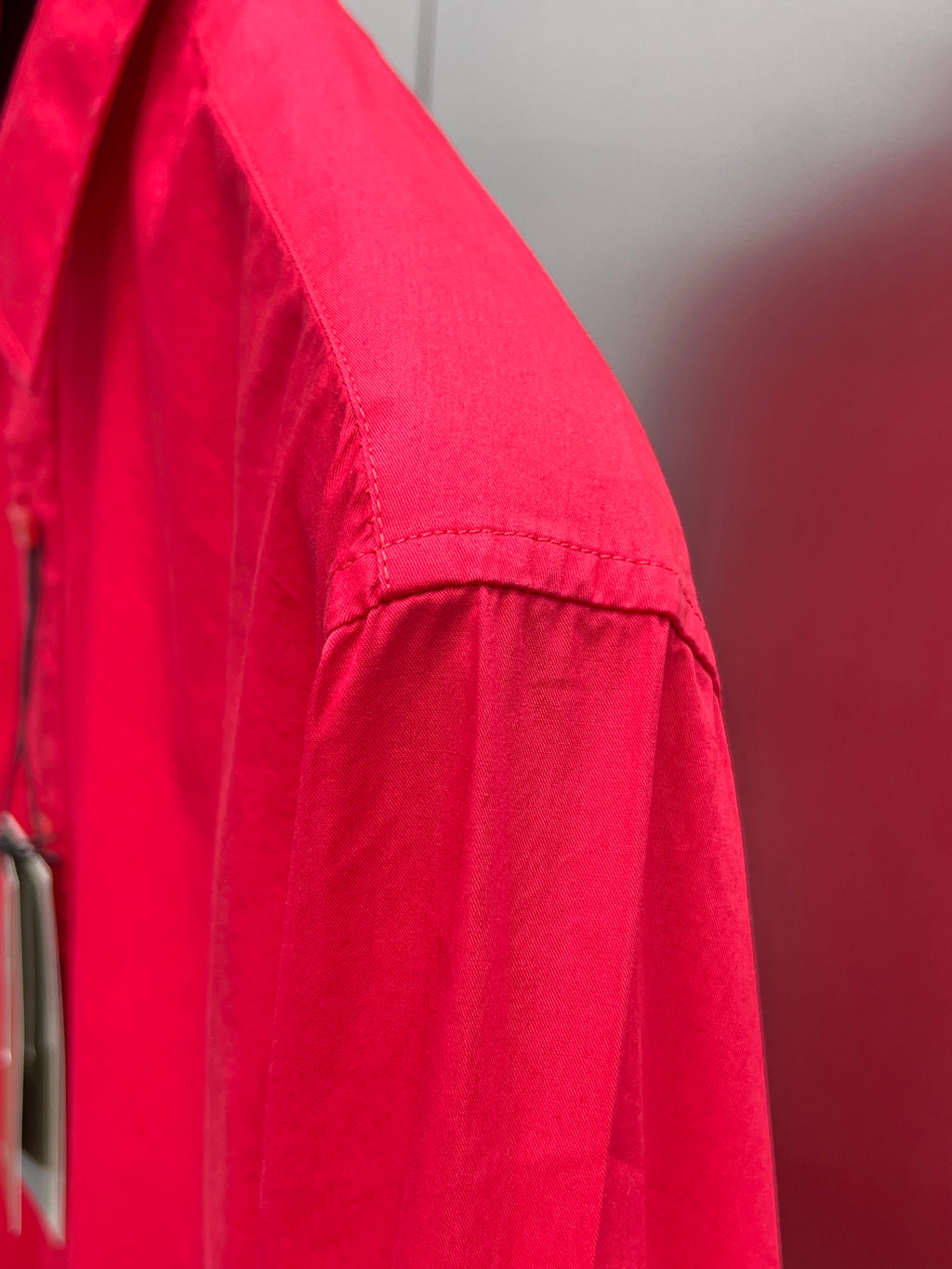 Red long-sleeve shirt sleeve with visible seam and shoulder panel