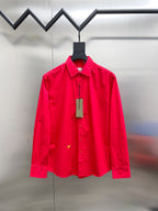 Red long-sleeve button-up shirt with front placket and chest detail