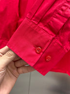 Red long-sleeve shirt cuff detail with two button placket and stitched seam