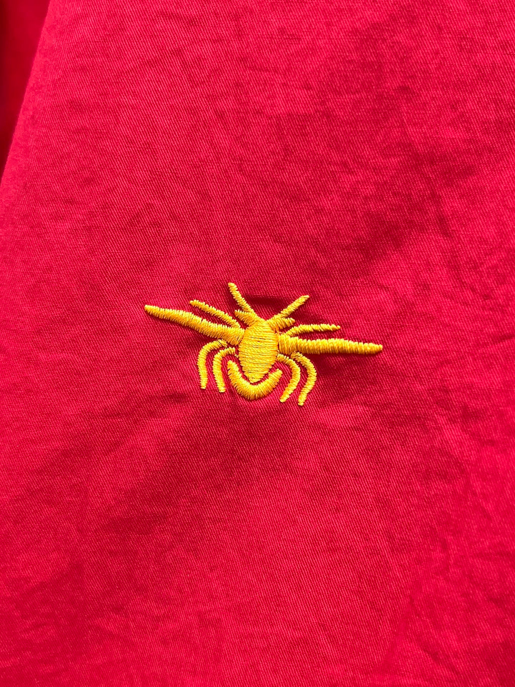 Red shirt with small yellow emblem embroidery