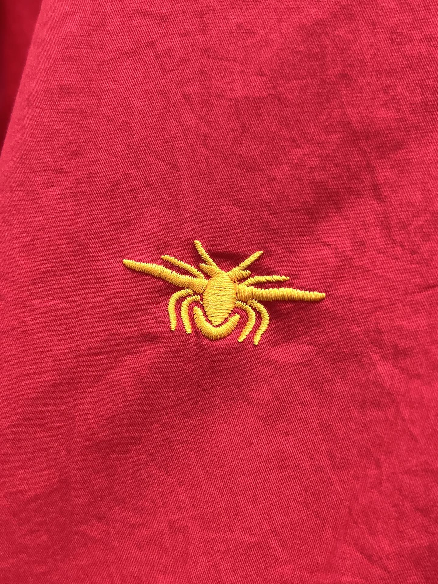 Red shirt with small yellow emblem embroidery