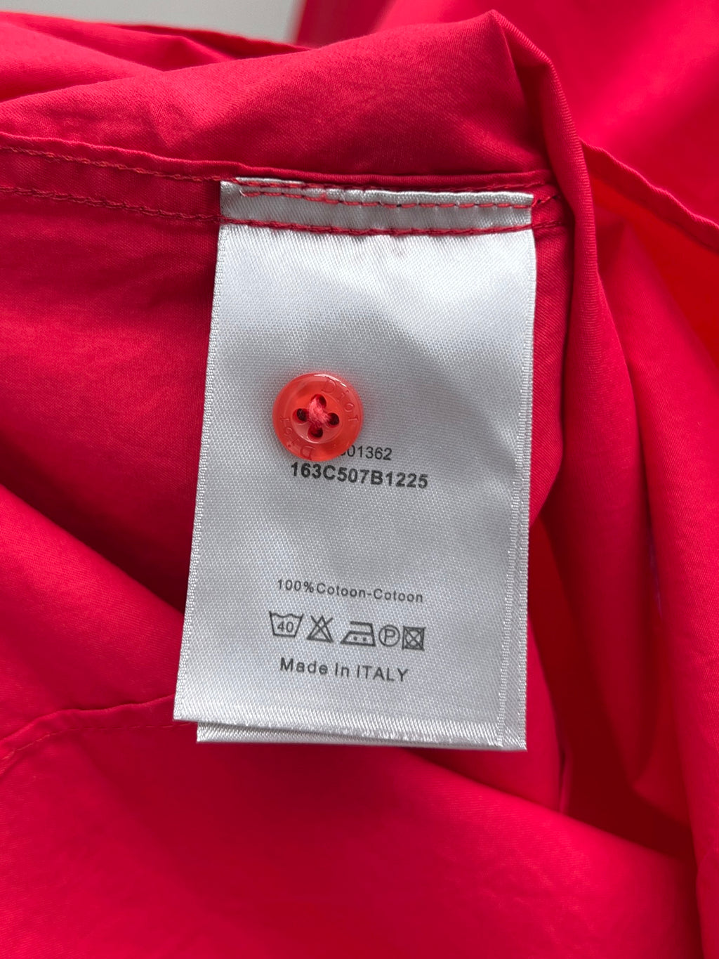Red clothing label on shirt with care instructions and Made in Italy
