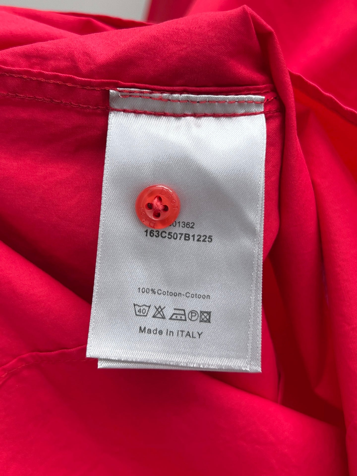 Red clothing label on shirt with care instructions and Made in Italy
