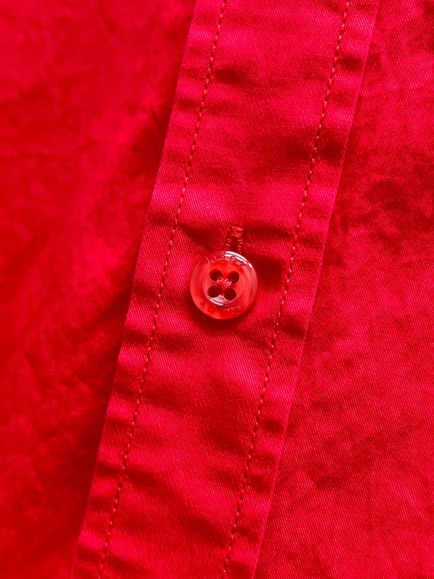 Red shirt button detail on stitched placket