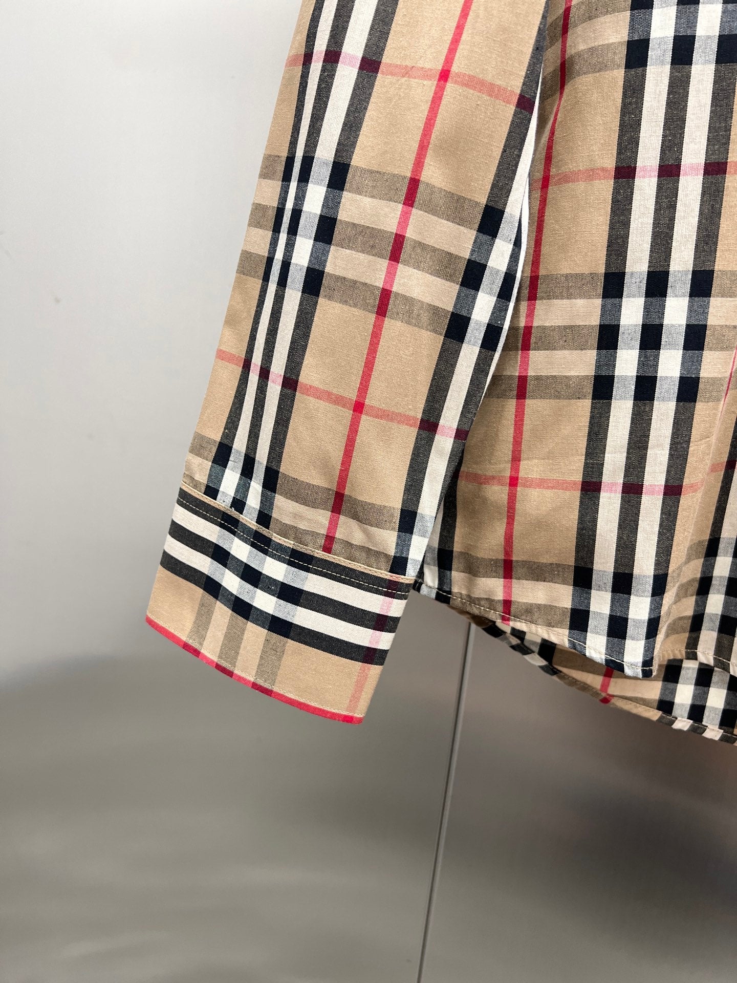 Burberry plaid shirt hem and sleeve edge with beige, navy, and red check pattern