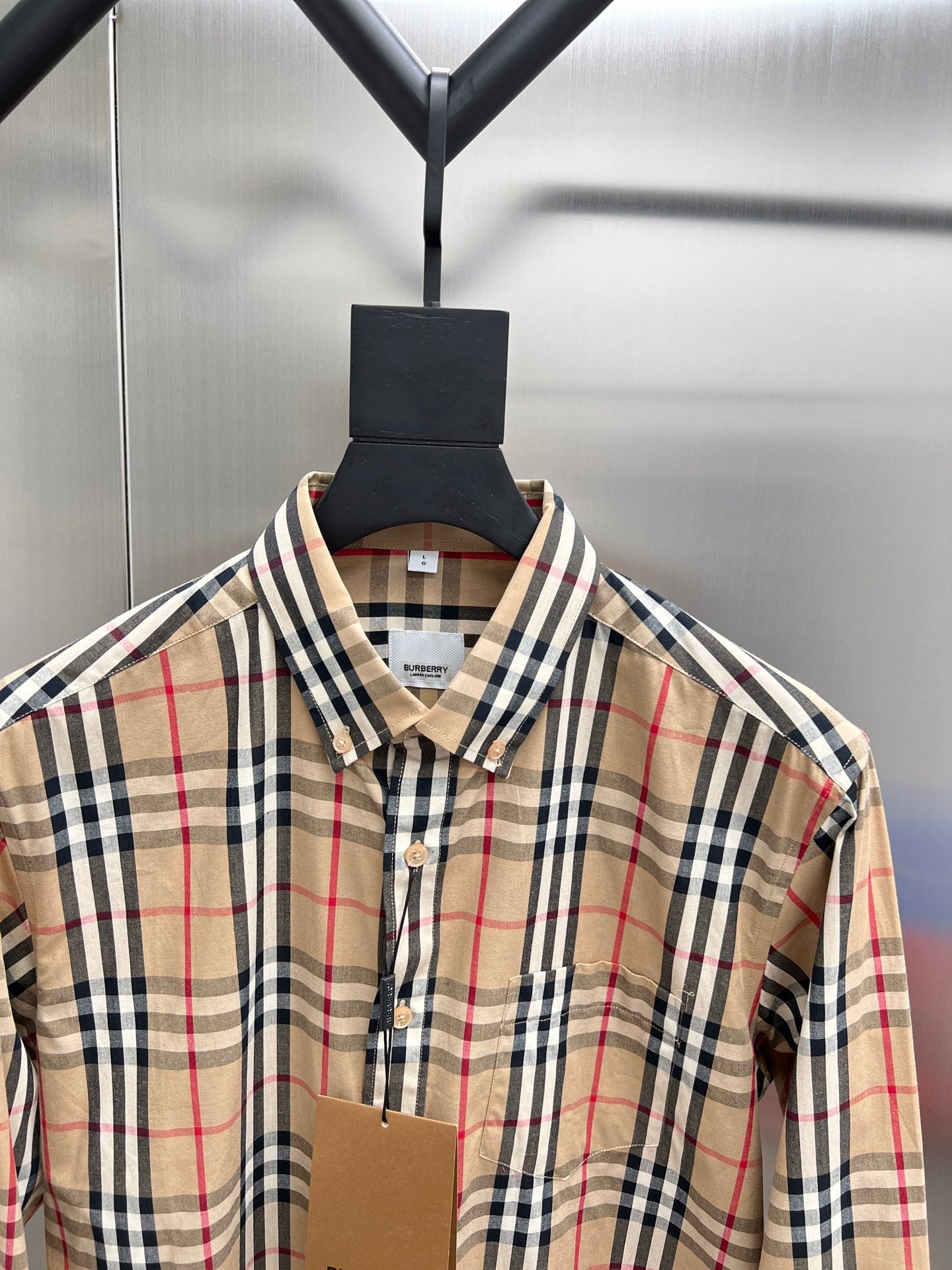 Burberry plaid shirt close-up at collar with button placket and beige fabric