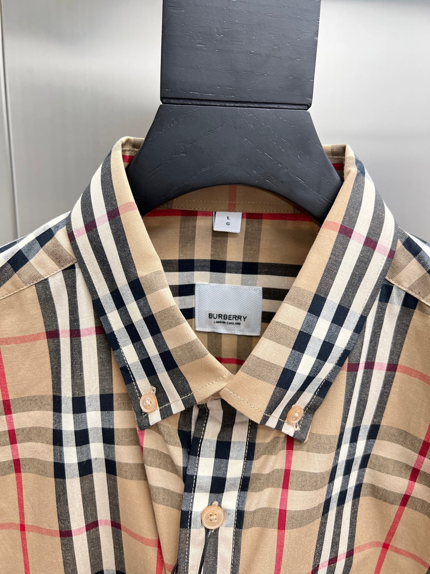 Burberry plaid shirt neckline with tag, pointed collar, and beige front buttons