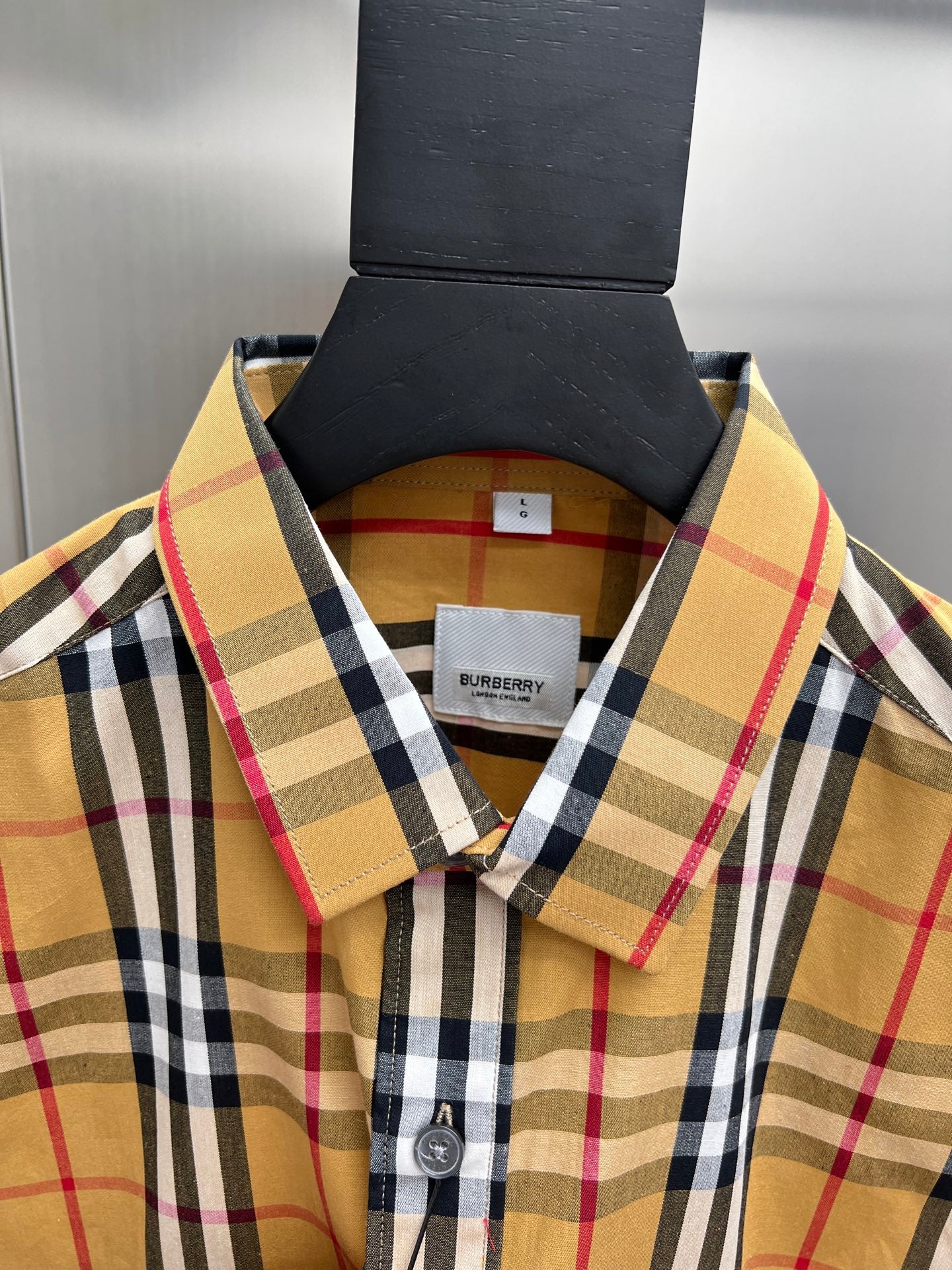 Burberry plaid shirt collar close-up with button placket and brand label
