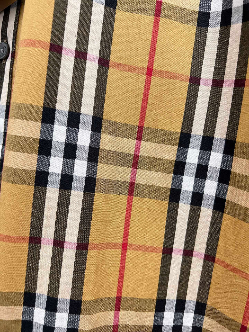 Burberry plaid fabric close-up in tan, black, white, and red tones
