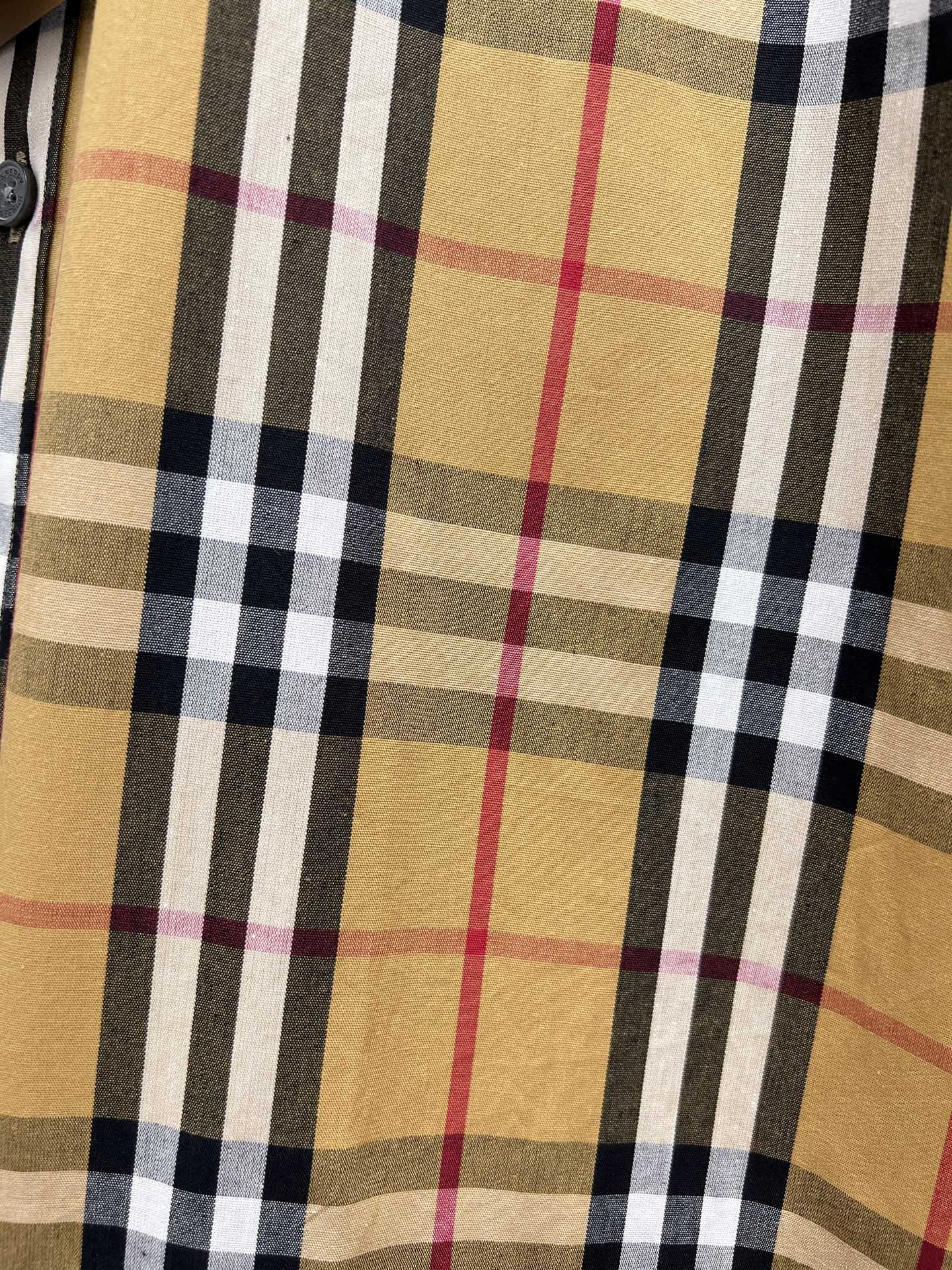 Burberry plaid fabric close-up in tan, black, white, and red tones