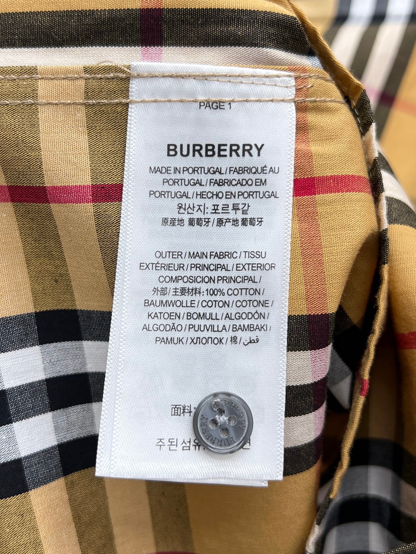 Burberry fabric label on plaid shirt, showing care info and material composition