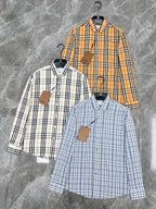 Set of Burberry plaid shirts on hangers: white, orange, and light blue button-ups