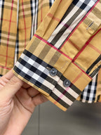 Long-sleeve plaid shirt cuff with two buttons and contrast trim, tan and dark checks