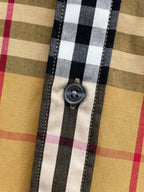 Burberry plaid shirt button close-up with dark stitched placket