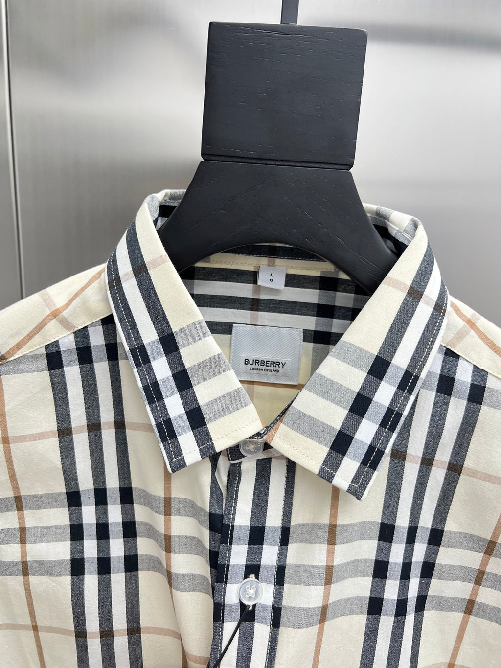 Long-sleeve plaid button-up shirt with button placket, cream with navy and tan checks.