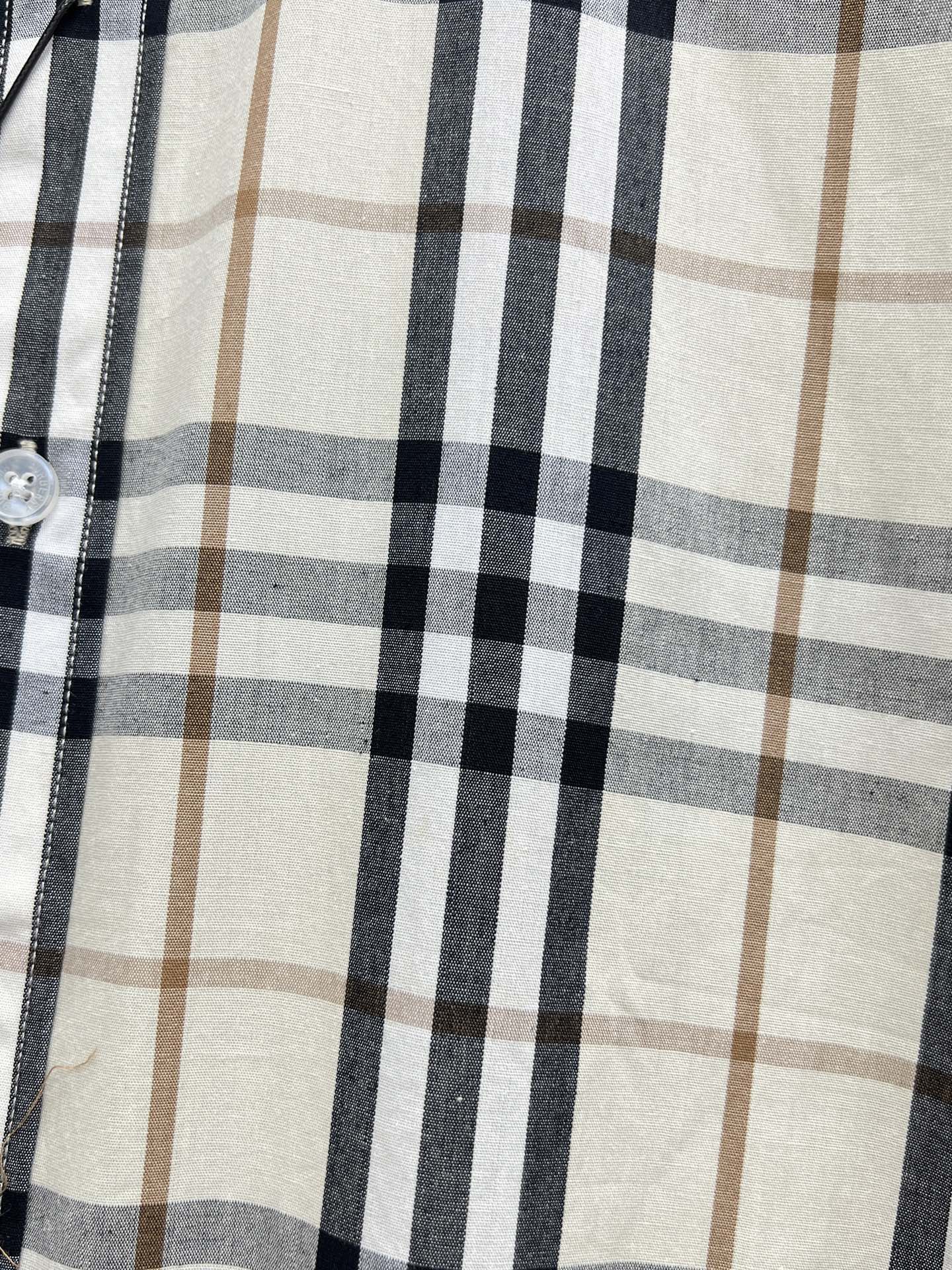 Plaid pattern on long-sleeve shirt, cream ground with navy and tan grid lines.