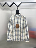 Long-sleeve plaid button-up shirt on hanger, cream with navy and tan checks.