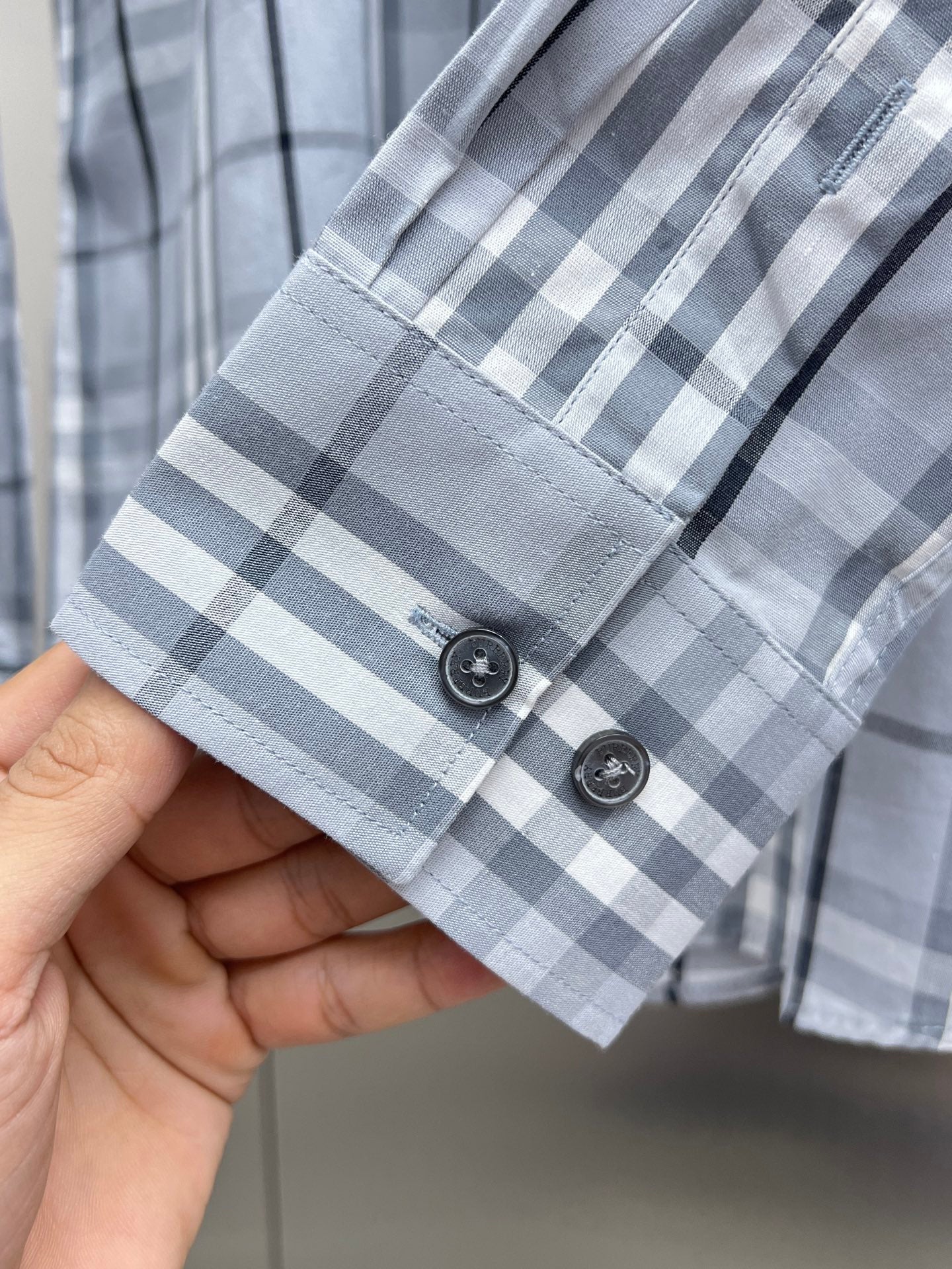 Light blue plaid shirt cuff with two button placket detail