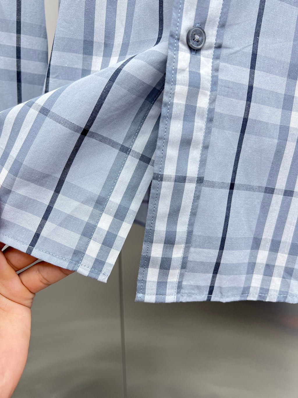 Light blue and navy plaid long-sleeve shirt with button cuff