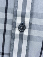 Burberry plaid shirt button close-up on light blue and white check fabric