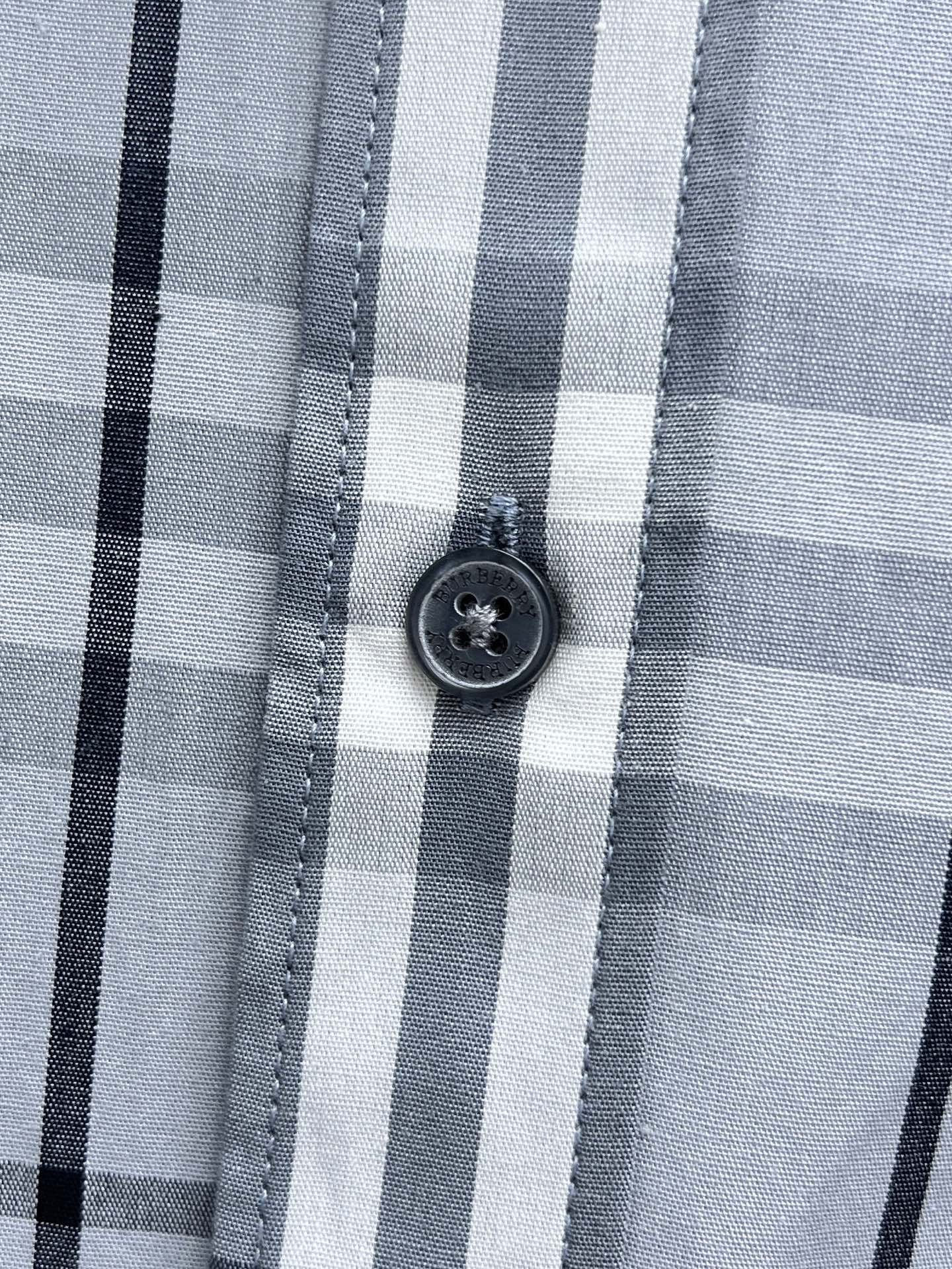 Burberry plaid shirt button close-up on light blue and white check fabric