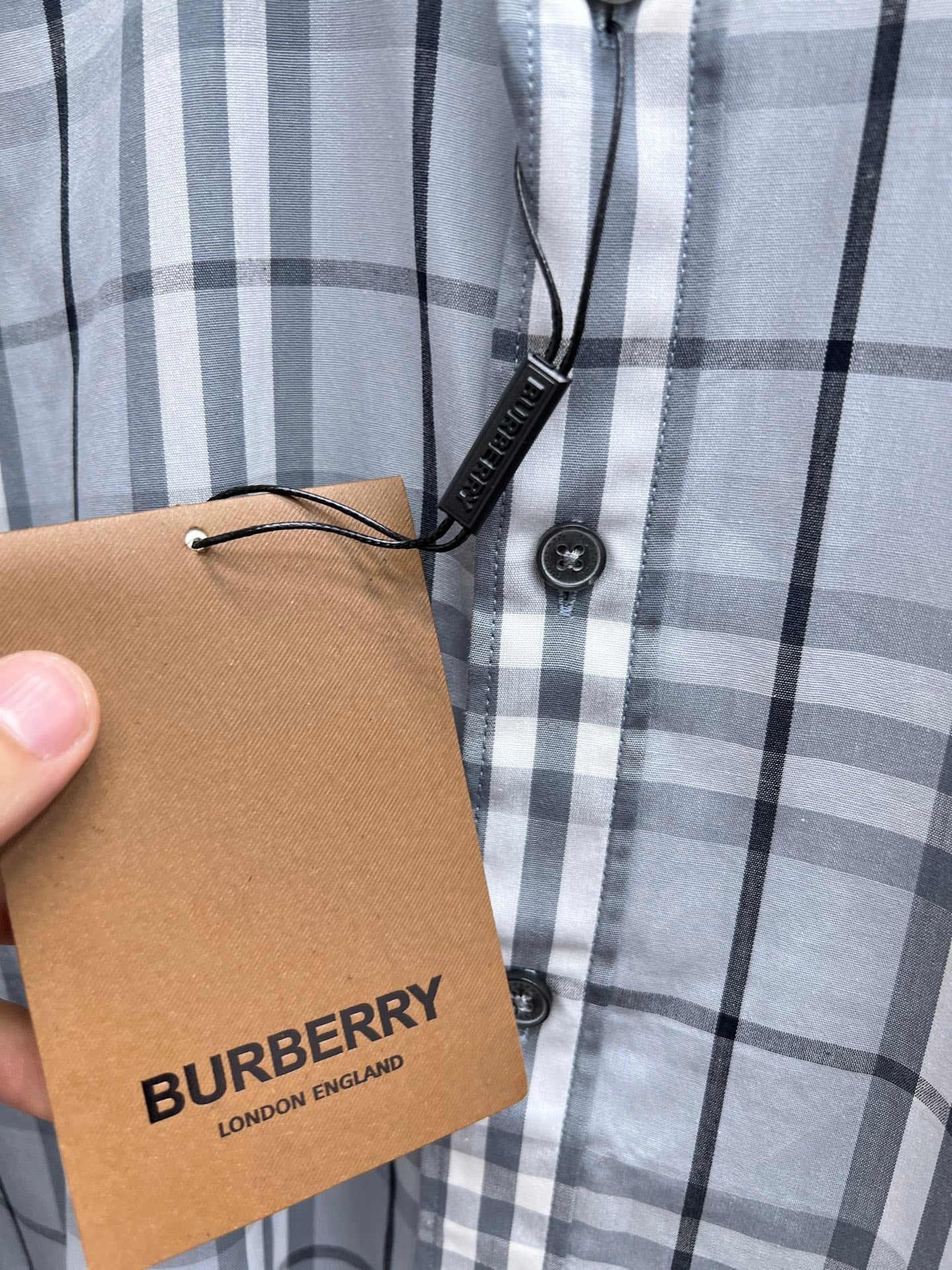 Burberry plaid shirt button placket with hanging tag, light blue and white check
