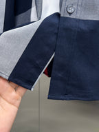 Navy long-sleeve shirt cuff with button and contrast striped fabric