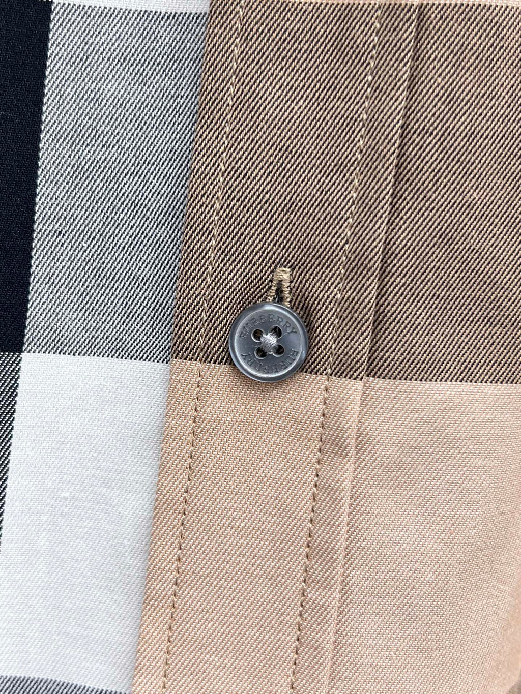 Beige plaid shirt button close-up on collar placket
