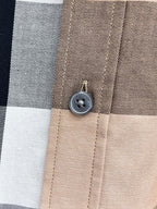 Beige plaid shirt button close-up on collar placket