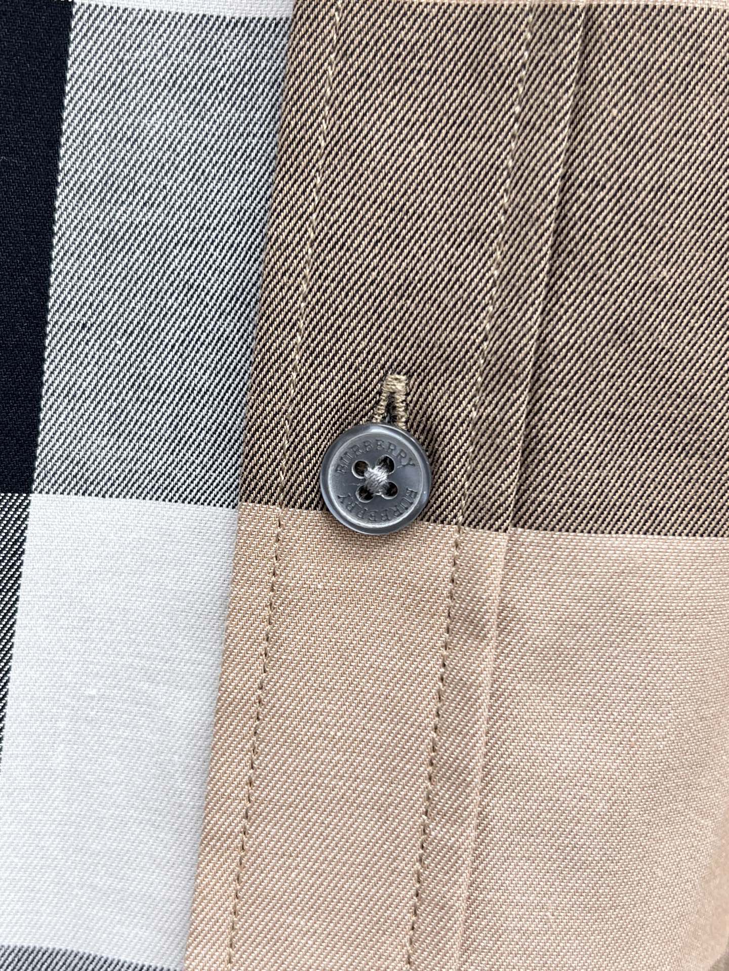 Beige plaid shirt button close-up on collar placket