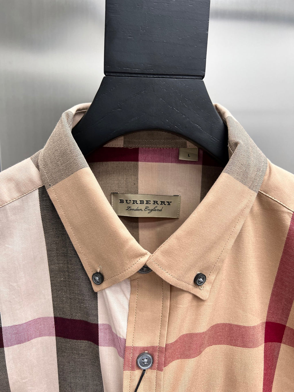 Burberry beige plaid button-up shirt collar with brand hang tag and button placket