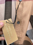 Beige plaid button-up shirt with hang tag attached to button placket