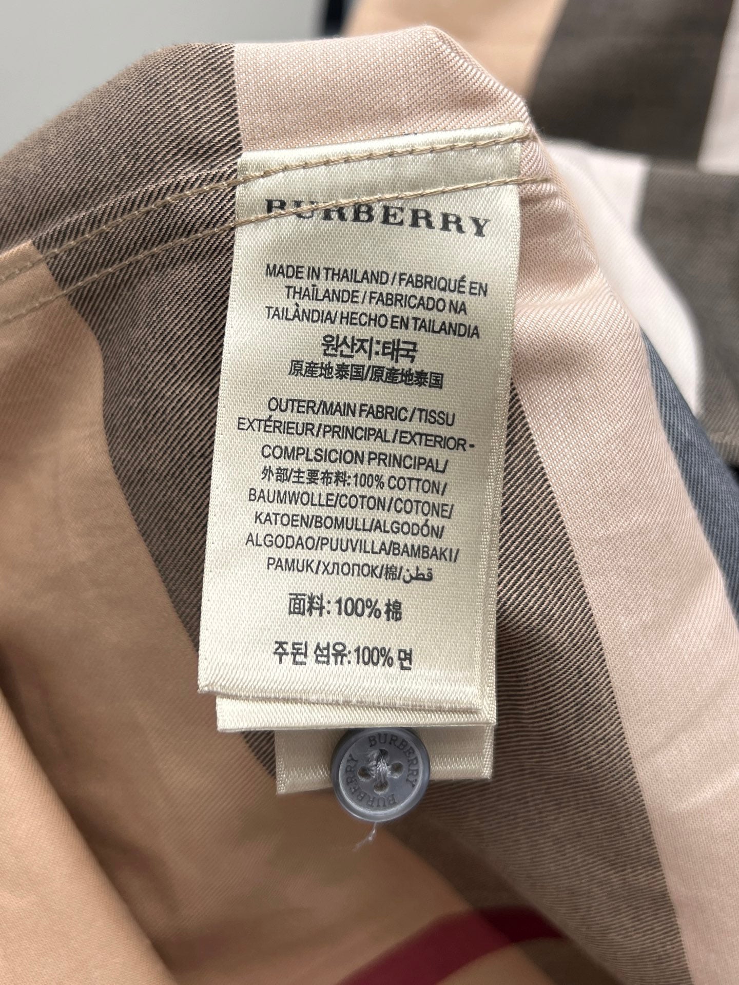 Burberry plaid shirt neck label with fabric content and care instructions