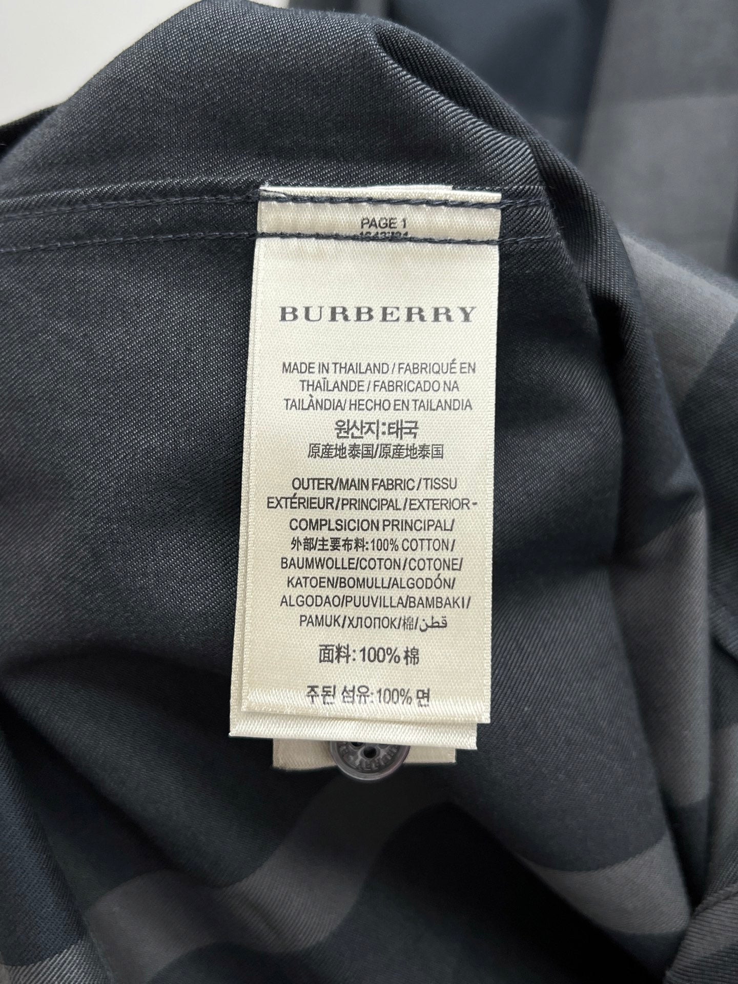 Burberry fabric label on dark long-sleeve shirt with care and material text