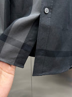 Dark long-sleeve shirt cuff with round buttons and check trim