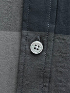 Burberry check shirt button and stitched placket detail on dark blue-gray fabric