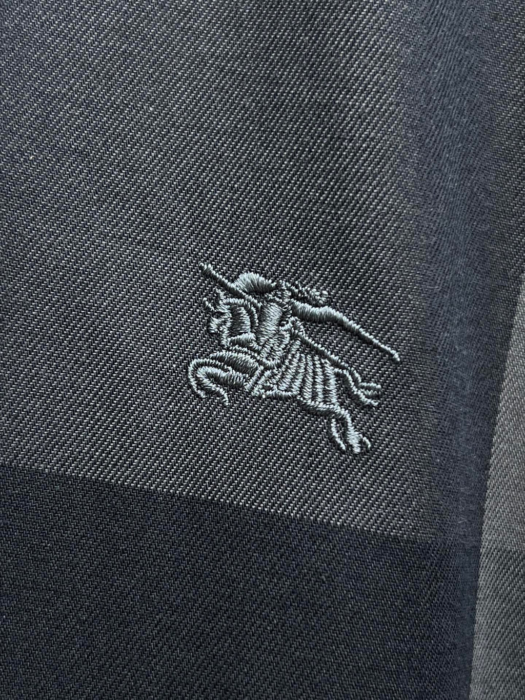 Burberry horse logo embroidery on dark blue-gray plaid shirt fabric