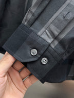 Dark long-sleeve shirt sleeve cuff with button placket and plaid