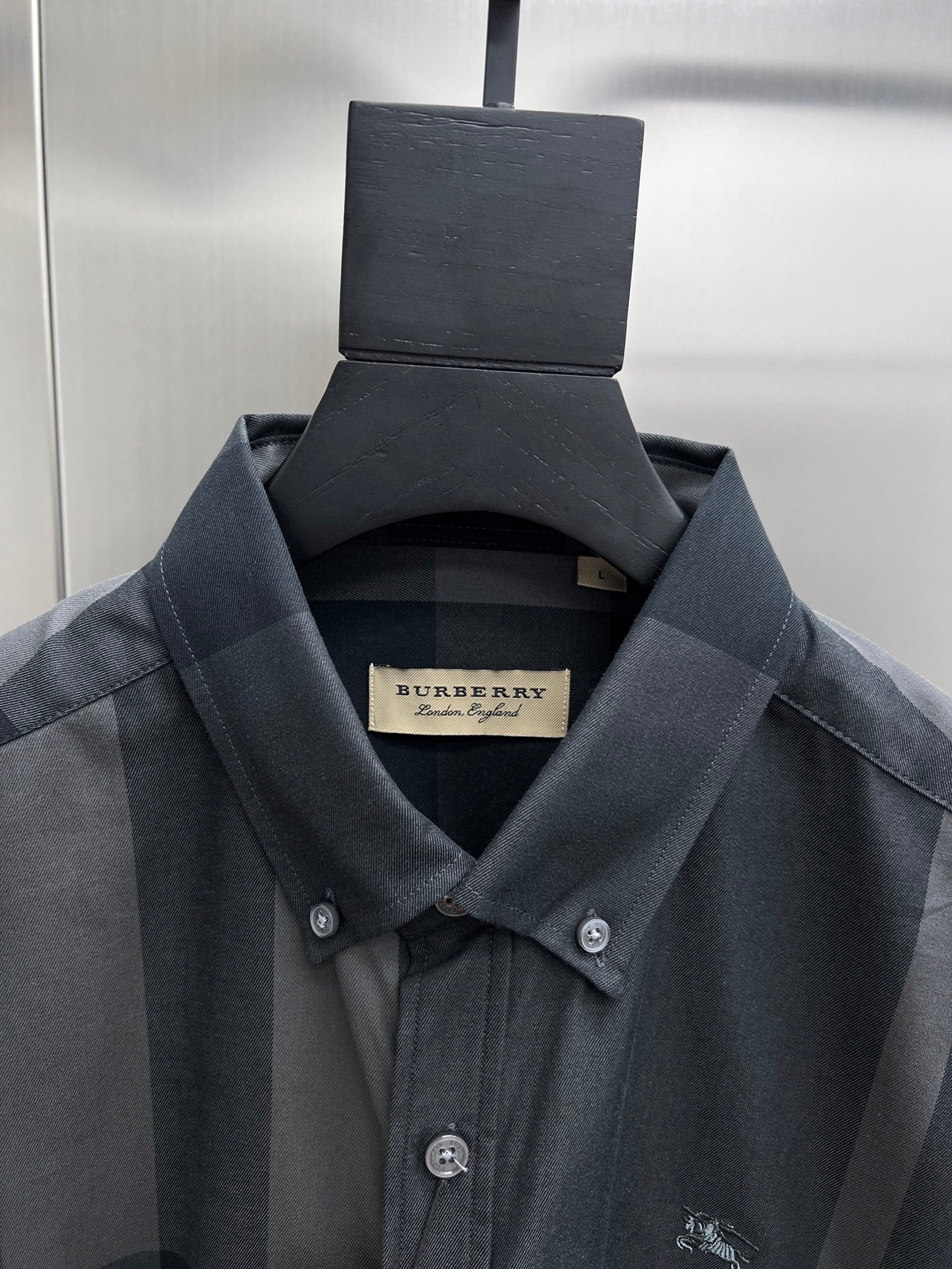 Burberry check long-sleeve shirt close-up, dark blue-gray fabric with small chest logo