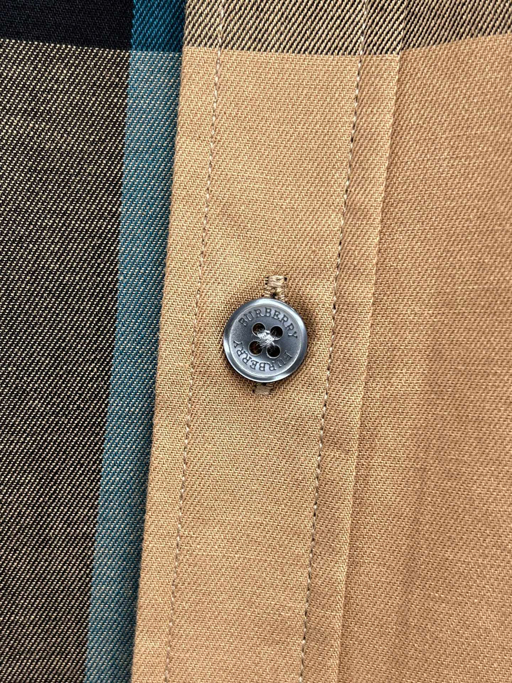 Burberry logo button on beige shirt placket with stitched panel