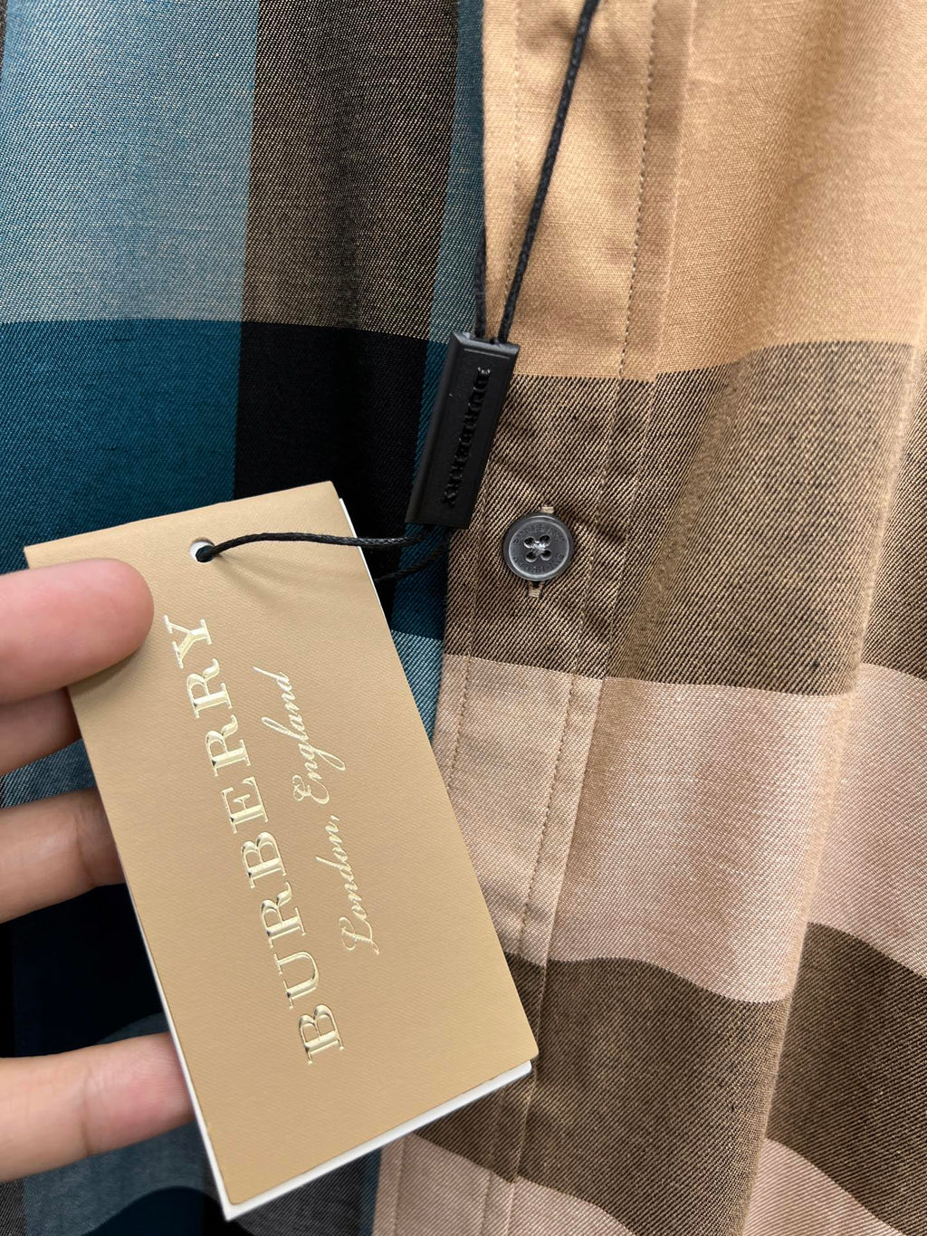Burberry shirt with hang tag near button placket on beige and blue plaid