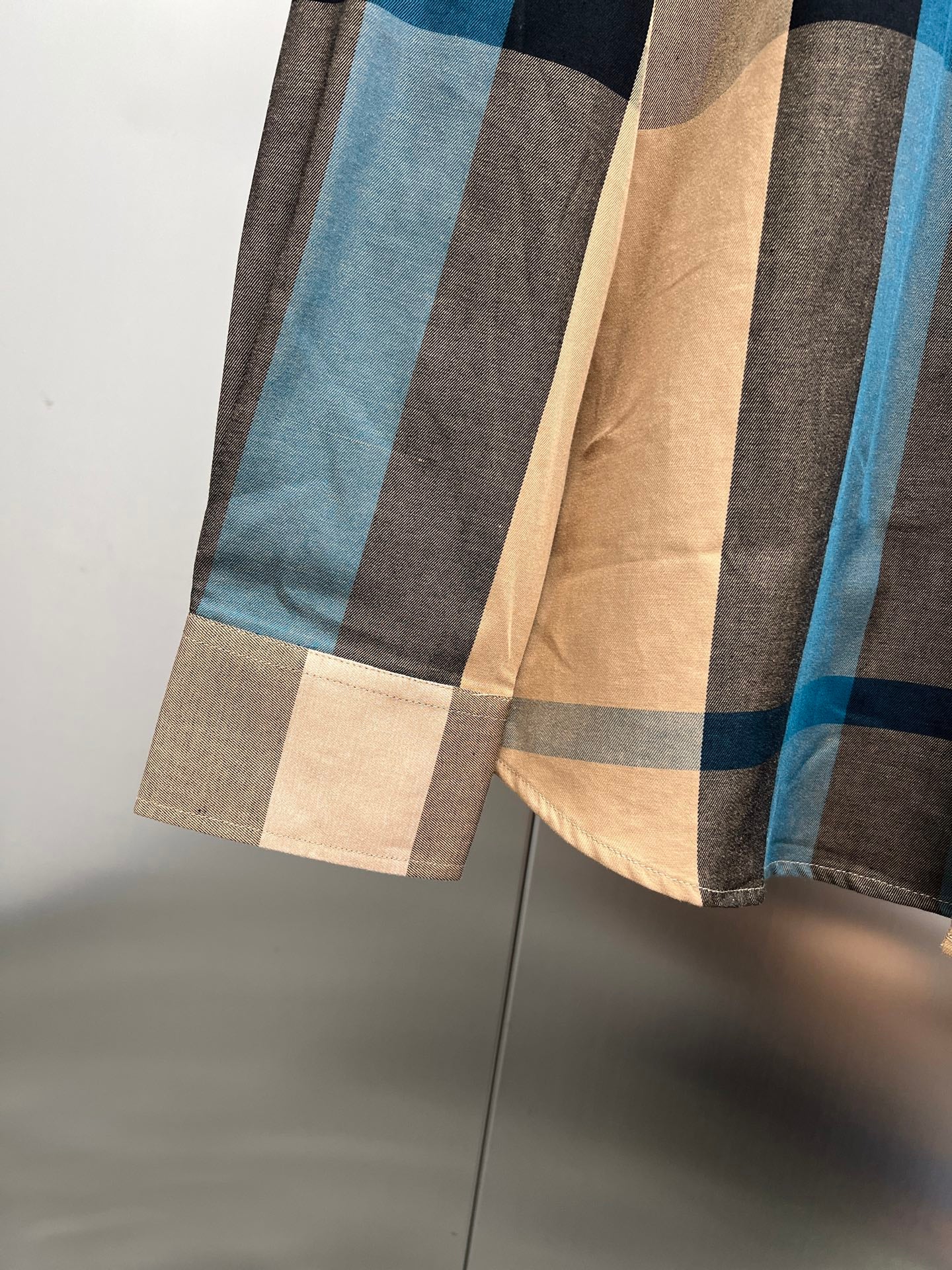 Burberry shirt lower section with plaid hem in beige, blue, and dark tones