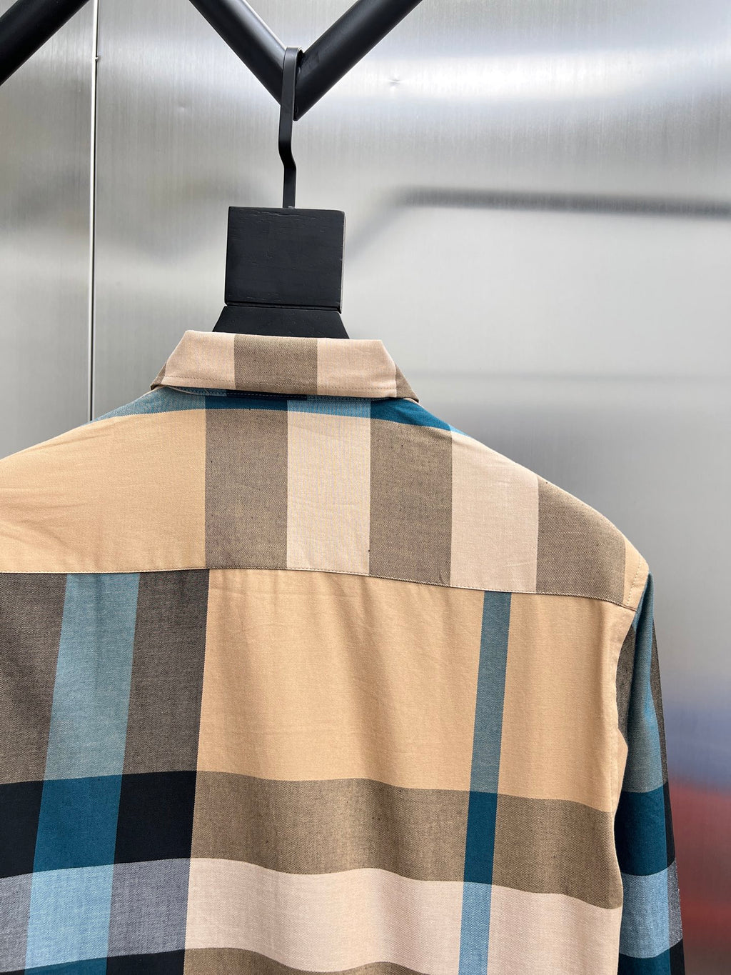 Check-pattern long shirt on hanger with tan, blue, and dark block squares