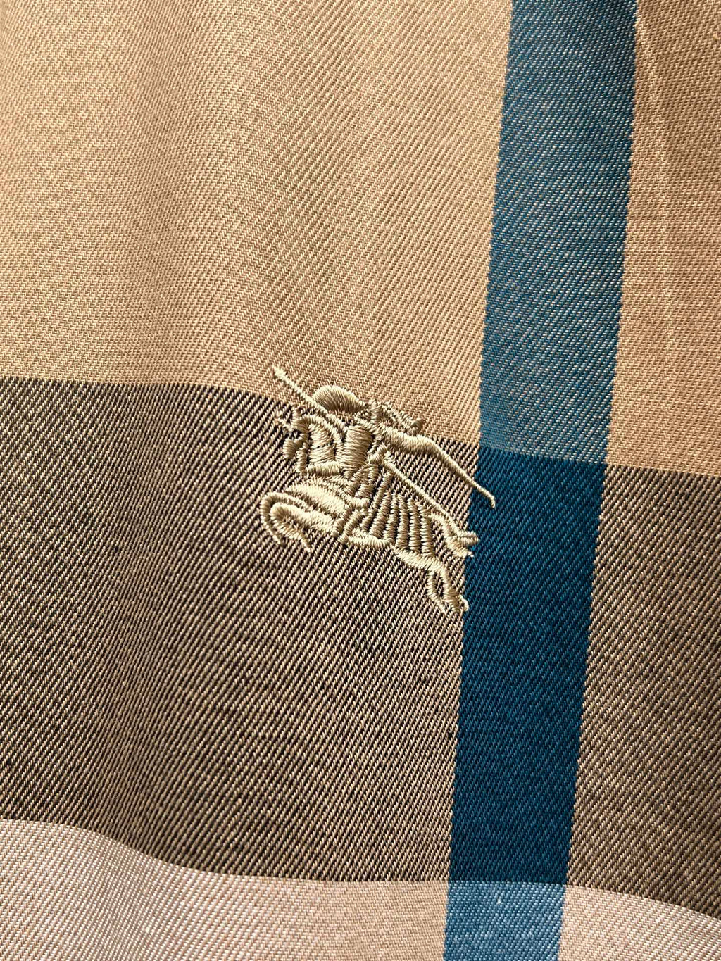 Burberry embroidered crest logo on beige and blue plaid fabric